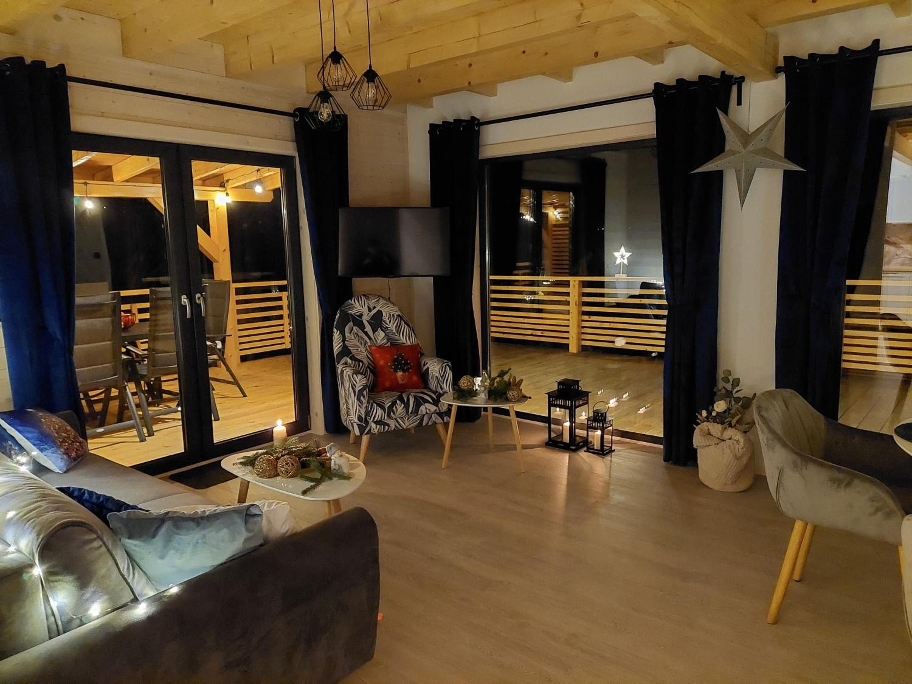 Salon wieczorem, z sofą, fotelem i lampionami